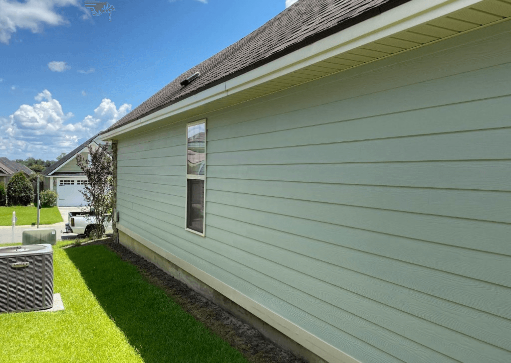 Clean light-green lap siding on a residential home after soft washing
